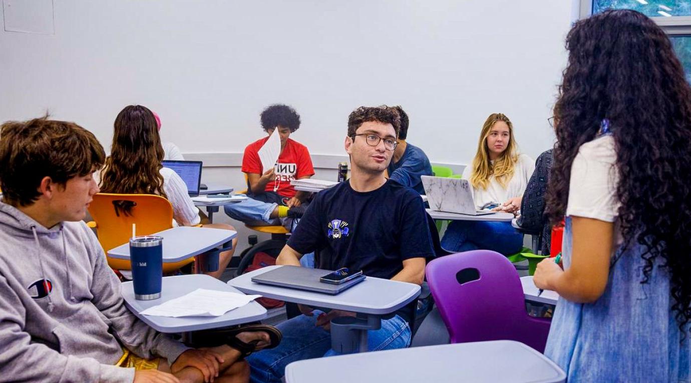 A Pitzer student asks his professor a question during class